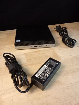 un ordinateur portable et un chargeur posés sur une table en bois
