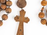 several wooden beads and a wooden cross on a white surface