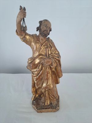 bronze statue of a man holding a staff on a white surface