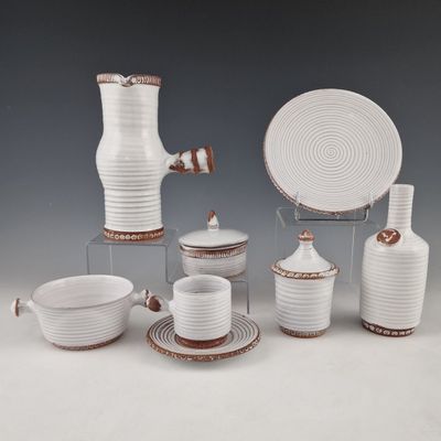 a group of white dishes and cups on a table