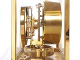 a gold clock that is sitting in a glass case