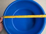 someone is measuring the height of a blue bowl with a tape