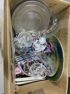 a cardboard box filled with many different types of dishes