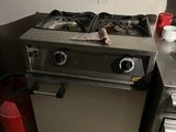 a silver stove top oven sitting in a kitchen next to a sink