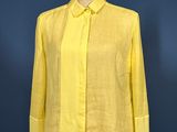 yellow shirt on a mannequin stand against a blue wall