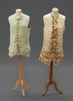 two mannequins of different sizes and colors on a stand