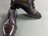 pair of men ' s leather shoes with laces on them on a gray surface