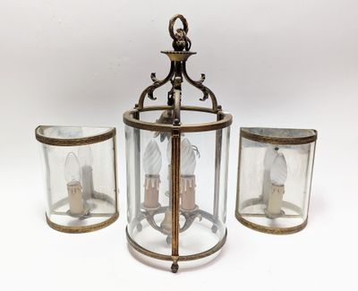 une image représentant une lanterne suspendue à trois lumières, avec une horloge à l'intérieur