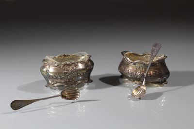 deux cuillères en argent et un bol en argent posés sur une table