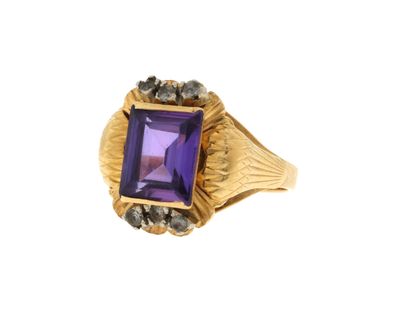 un gros plan d'une bague ornée d'une pierre violette entourée de diamants noirs