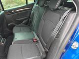 the back seats of a blue car with a black seat belt