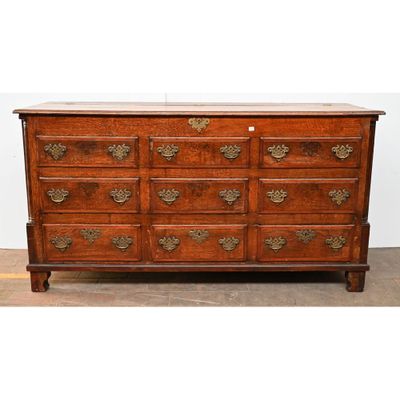 une commode ancienne en chêne avec des poignées en laiton