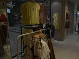 a lot of clothes hanging on a rack in a store