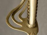 a close up of a sword with a metal handle on a gray background
