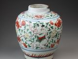 a white vase with red and green designs on it