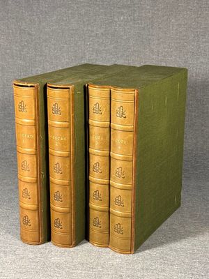 three books are stacked on top of each other on a gray surface