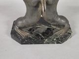 a statue of two hands holding a bird on top of a table