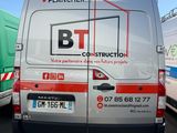 une camionnette blanche garée sur un parking à côté d'autres camions
