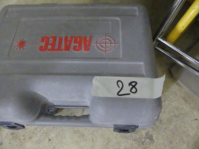 une valise sur laquelle est collé un autocollant, posée par terre