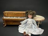 une poupée assise à côté d'un piano