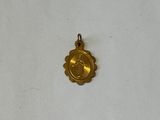 a small gold medal on a white surface