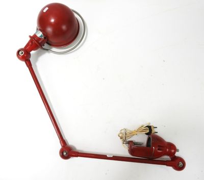une lampe rouge posée sur une table blanche