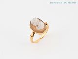 une image d'une bague en or avec une pierre blanche au centre
