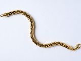 bracelet plaqué or avec un motif torsadé sur fond blanc