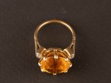 un gros plan d'une bague en or sertie d'une citrine