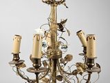 un lustre ancien en laiton, orné de cinq bougies et d'un oiseau