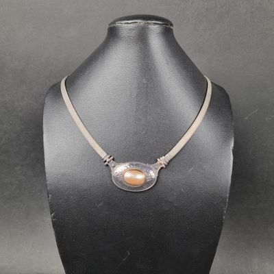 un collier orné d'une perle autour du cou d'un mannequin