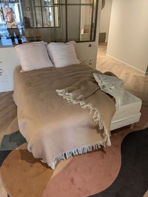 un lit recouvert d'une couverture dans une chambre