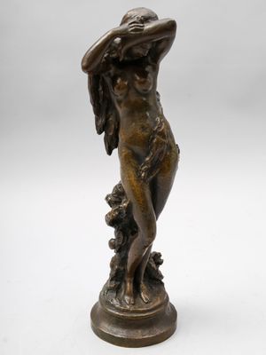 une statue en bronze d'une femme avec un chapeau sur la tête