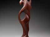 a wooden sculpture of a woman holding a baby in her arms
