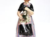 a figurine of a woman holding a bottle of wine