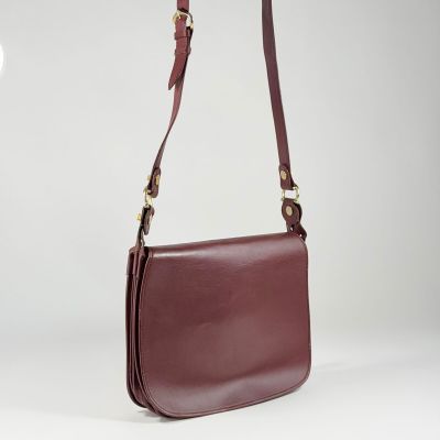 un sac à bandoulière en cuir marron avec une longue bandoulière, sur fond blanc