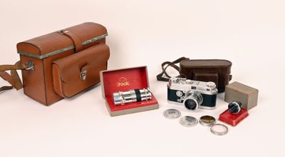 un sac en cuir marron sur lequel sont posés un appareil photo et d'autres objets