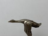 statue d'un oiseau posée sur un socle blanc, avec un fond blanc