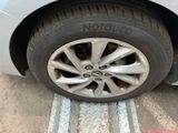a cat that is sitting on the tire of a car