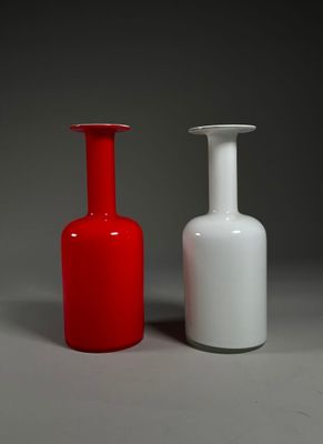 deux vases rouges et blancs posés l'un à côté de l'autre sur une surface grise