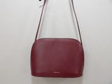 a red purse hanging on a wall with a white background