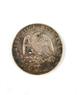 an old coin with a bird on it sitting on a white surface