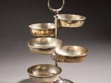 an image of a three tiered silver plate with a handle