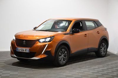 Le SUV orange est garé dans une pièce dont le sol est à carreaux.