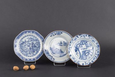 trois assiettes bleues et blanches ornées de motifs et des noix