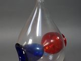 un vase en verre contenant une boule rouge, blanche et bleue