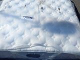 un matelas posé à même le sol sur le parking