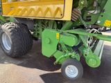 a green tractor with a yellow trailer parked in a parking lot