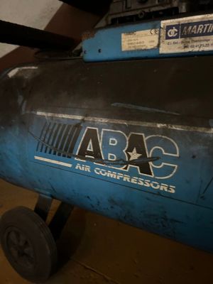 un compresseur d'air bleu posé dans un garage
