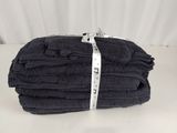 une pile de serviettes noires pliées posée sur une table blanche